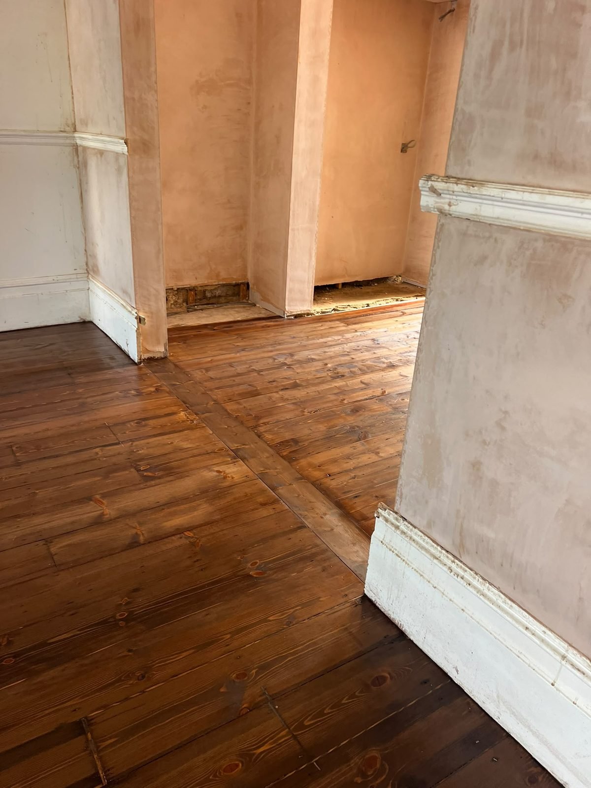 Worn and darkened pine floorboards before sanding