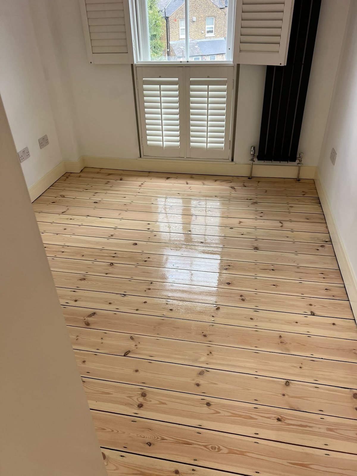Pine floorboards sanded and sealed in a room with shutters