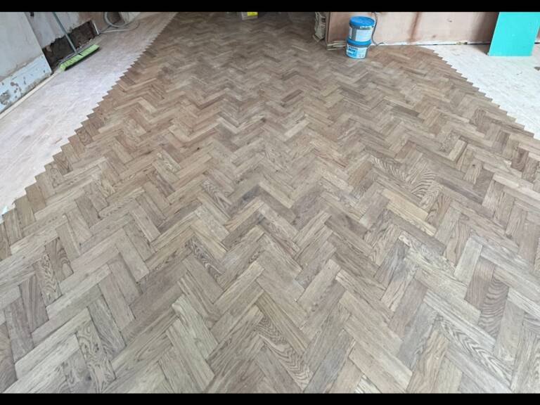 Oak herringbone parquet blocks being laid in a double herringbone pattern